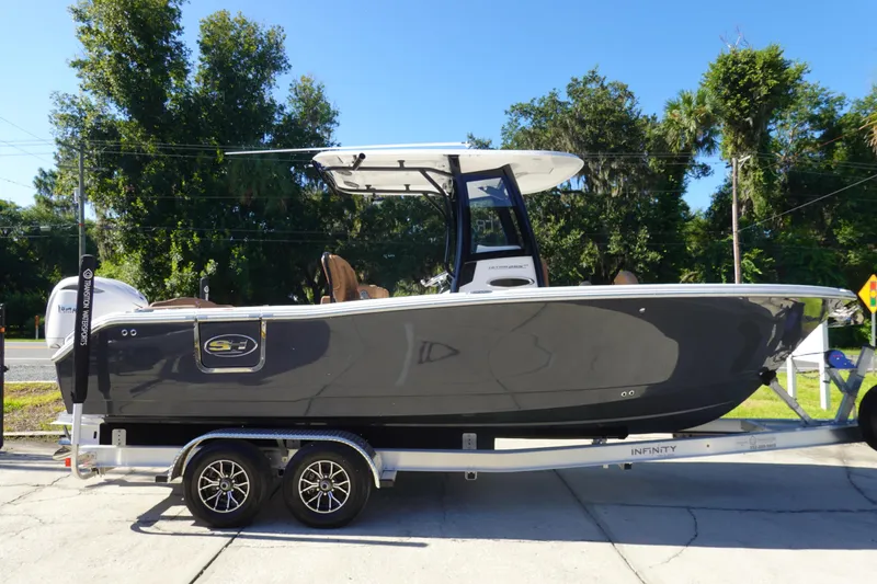 Slide: The Image of 2026 Sea Hunt Ultra 255 SE boat on trailer, parked outdoors with trees in background. - 6