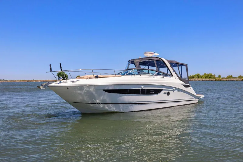 Slide: The Image of 2014 Sea Ray 350 Sundancer yacht cruising on calm waters under clear blue sky. - 0
