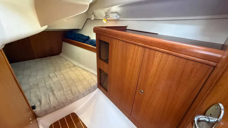 Slide: The Image of Cozy cabin interior of 2002 Hunter 326 sailboat with wooden cabinetry and bed. - 10