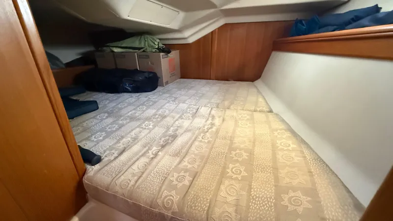 Slide: The Image of Cozy cabin interior of 2002 Hunter 326 sailboat with storage boxes and bedding. - 11