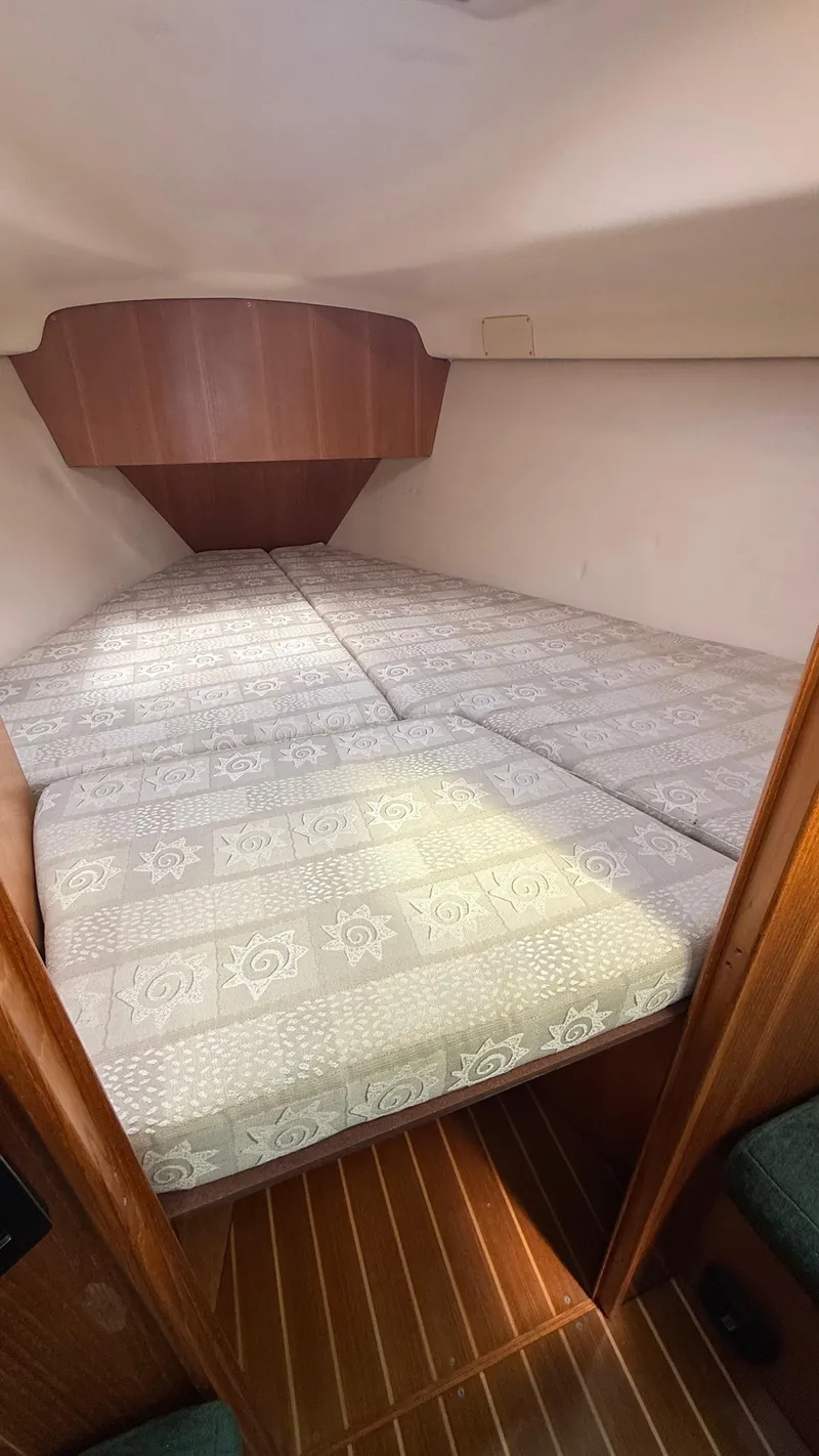 Slide: The Image of Cozy cabin interior of 2002 Hunter 326 sailboat with patterned bedding. - 12