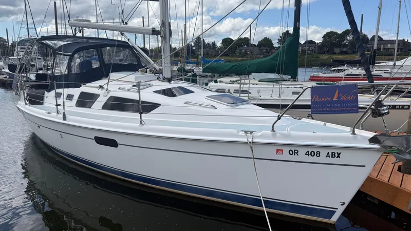 Slide: The Image of 2002 Hunter 326 sailboat docked at marina, featuring sleek design and spacious cockpit. - 24