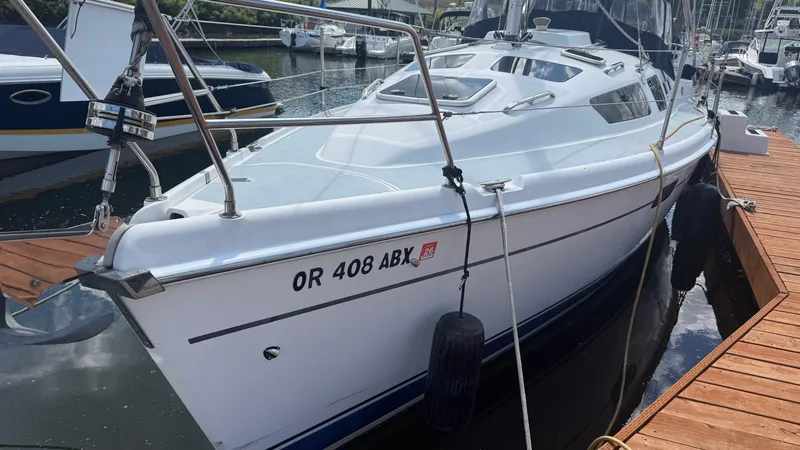 Slide: The Image of 2002 Hunter 326 sailboat docked at marina, featuring sleek design and white hull. - 28