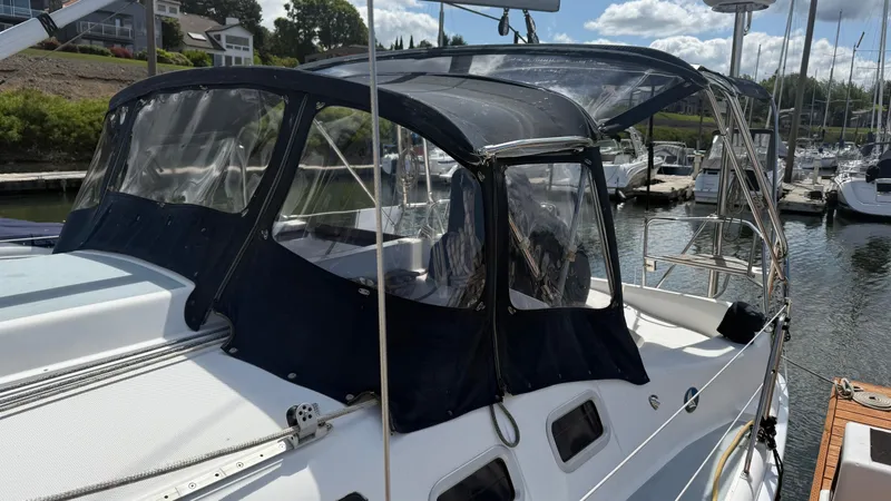 Slide: The Image of 2002 Hunter 326 sailboat with cockpit enclosure docked at marina. - 29