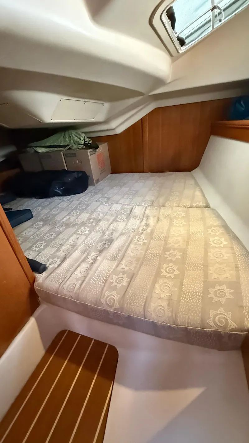 Slide: The Image of Cozy cabin interior of 2002 Hunter 326 sailboat with patterned mattress and wooden accents. - 8