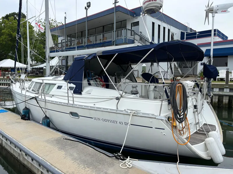 Slide: The Image of 2001 Jeanneau Sun Odyssey 43 DS sailboat docked at marina, featuring blue canopy. - 2
