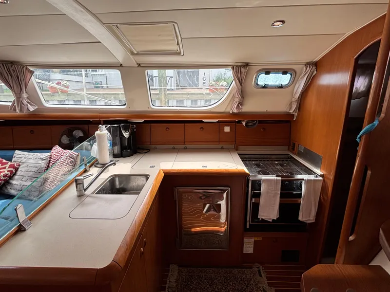 Slide: The Image of Interior of 2001 Jeanneau Sun Odyssey 43 DS yacht, featuring kitchen and seating area. - 29