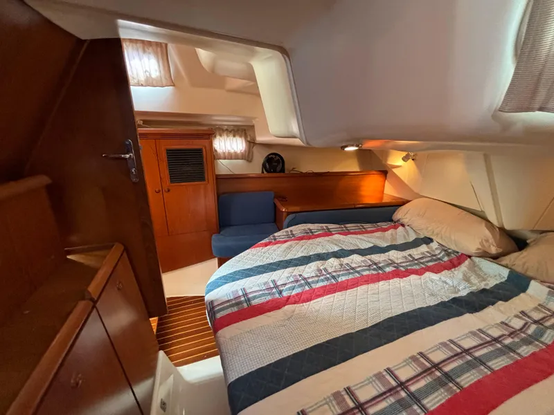 Slide: The Image of Cozy cabin interior of 2001 Jeanneau Sun Odyssey 43 DS with striped bedding and wooden accents. - 39