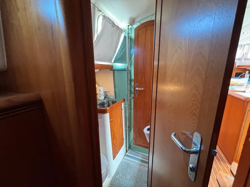 Slide: The Image of Interior of 2001 Jeanneau Sun Odyssey 43 DS yacht, featuring wooden cabinetry and compact bathroom. - 40