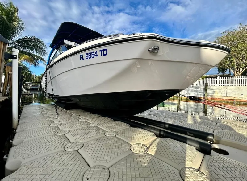 Slide: The Image of 2018 Yamaha Boats 242X E-Series on dock, sleek design, sunny day, palm trees in background. - 6