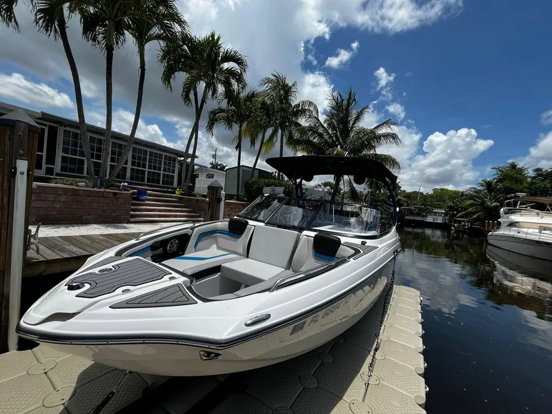 Slide: The Image of 2018 Yamaha Boats 242X E-Series docked by palm trees under a blue sky. - 7