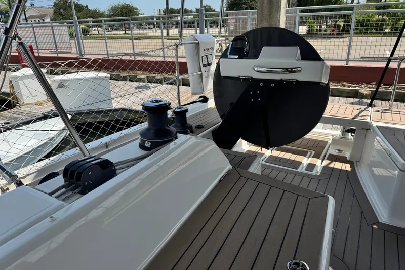 Slide: The Image of 2023 Dufour 530 yacht deck with steering wheel and winches at marina. - 17
