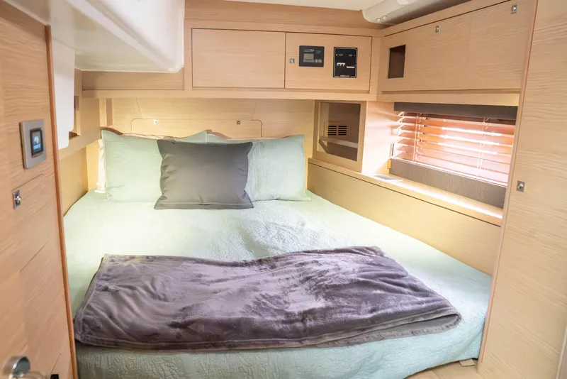 Slide: The Image of Cozy cabin interior of 2023 Dufour 530 yacht with bed and wooden accents. - 51