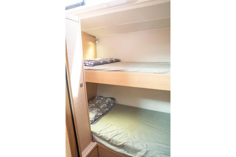 Slide: The Image of 2023 Dufour 530 yacht interior with cozy bunk beds and soft lighting. - 55