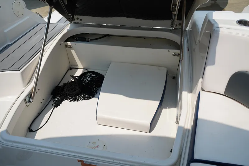 Slide: The Image of Open storage compartment in 2020 Chaparral 257 SSX boat, featuring a black net bag. - 10