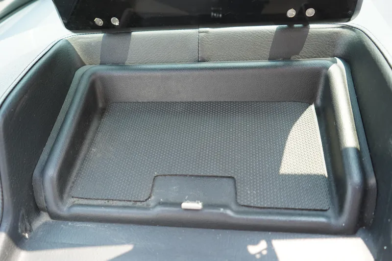 Slide: The Image of 2020 Chaparral 257 SSX boat storage compartment, black interior, open lid. - 18