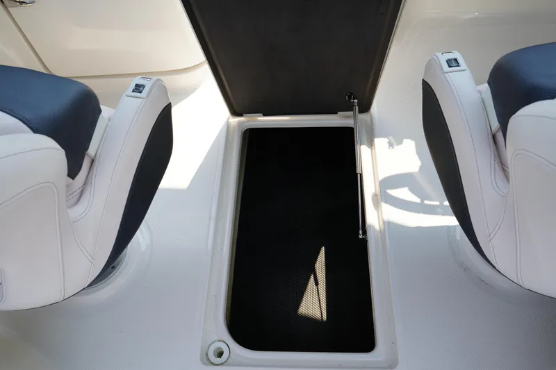 Slide: The Image of 2020 Chaparral 257 SSX boat interior with open storage compartment between seats. - 21