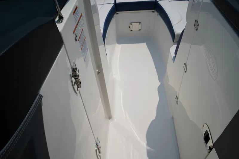 Slide: The Image of 2020 Chaparral 257 SSX boat interior with white flooring and storage compartments. - 22