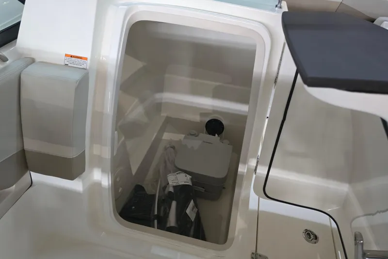 Slide: The Image of 2026 Boston Whaler 240 Vantage storage compartment with portable toilet and accessories. - 8