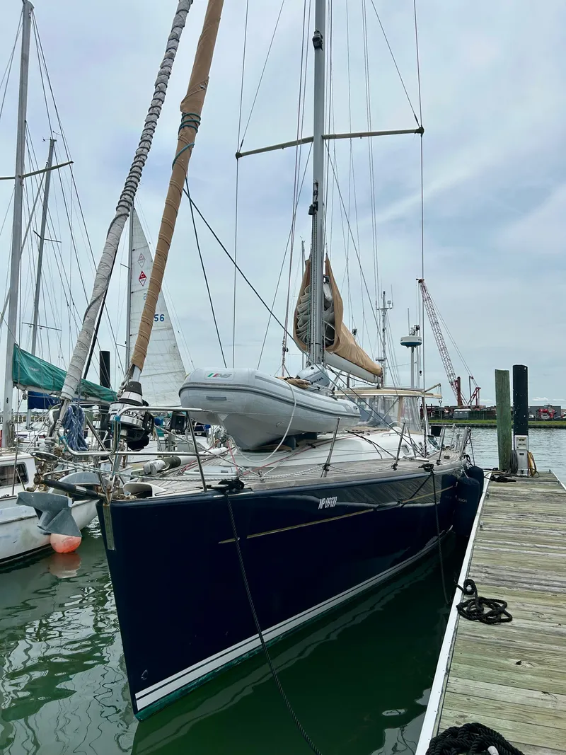 Slide: The Image of 2003 Beneteau First 47.7 sailboat docked at marina, featuring sleek design and tall mast. - 2