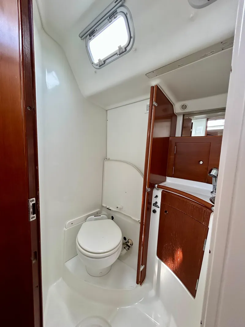 Slide: The Image of Beneteau First 47.7 2003 yacht bathroom with wooden cabinetry and compact design. - 26