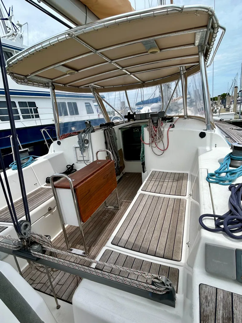 Slide: The Image of 2003 Beneteau First 47.7 sailboat cockpit with wooden seating and canopy. - 4