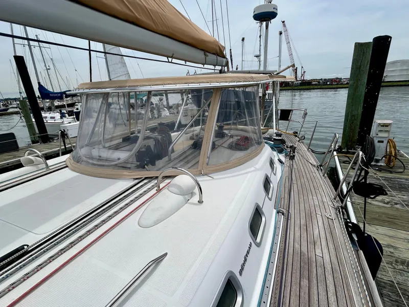 Slide: The Image of 2003 Beneteau First 47.7 sailboat docked at marina, featuring sleek design and spacious deck. - 6