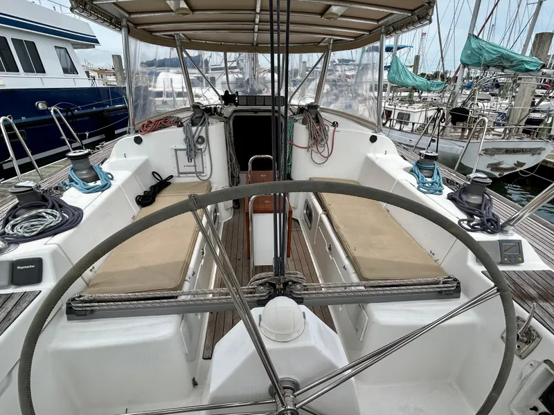 Slide: The Image of 2003 Beneteau First 47.7 sailboat cockpit with dual helm and seating, docked at marina. - 8