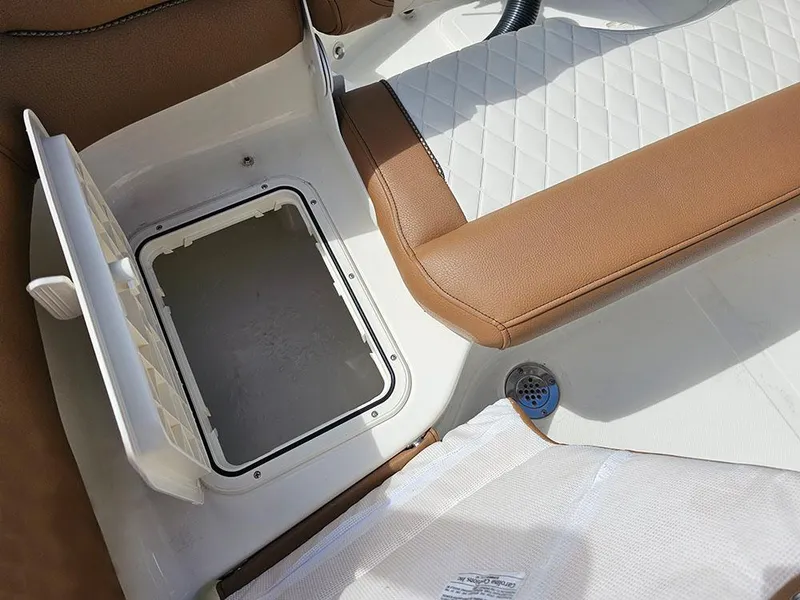 Slide: The Image of 2025 Pioneer 202 Islander boat interior with open storage compartment and brown seating. - 10