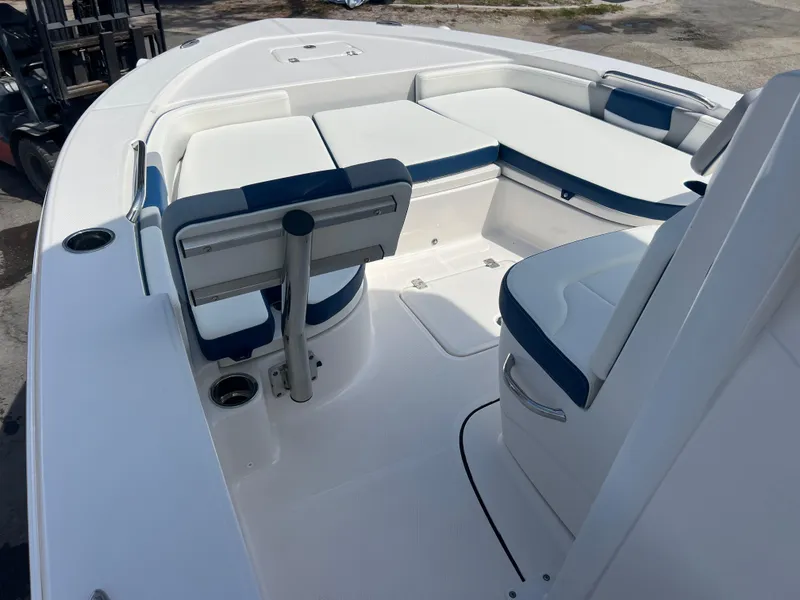 Slide: The Image of 2025 Robalo 226 Cayman boat interior with white and blue seating, spacious deck layout. - 10