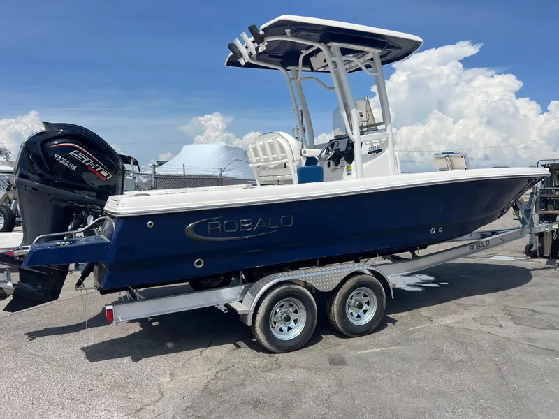 Slide: The Image of 2025 Robalo 226 Cayman boat on trailer, blue hull, Yamaha engine, sunny day. - 3