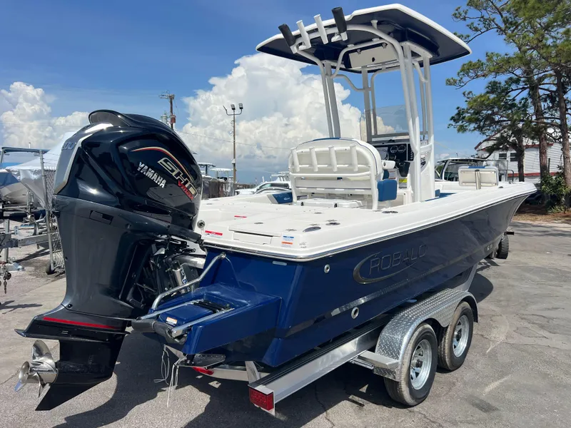 Slide: The Image of 2025 Robalo 226 Cayman boat on trailer with Yamaha engine, parked outdoors. - 4