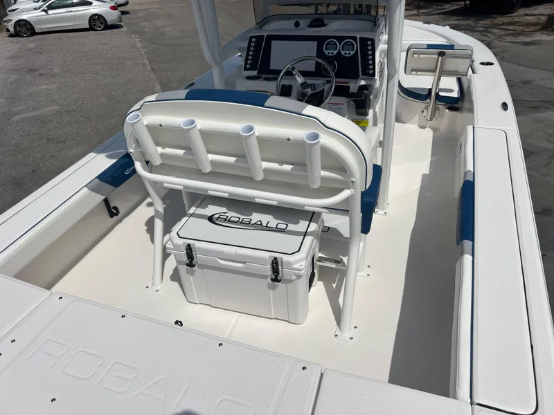 Slide: The Image of 2025 Robalo 226 Cayman boat interior with seating, console, and cooler. - 7