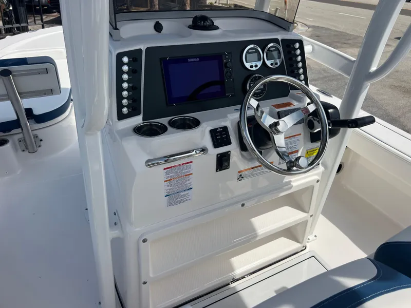 Slide: The Image of 2025 Robalo 226 Cayman boat dashboard with steering wheel and navigation controls. - 8