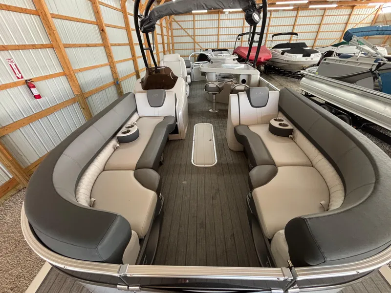 Slide: The Image of 2021 Avalon Catalina Entertainer 25' pontoon boat with spacious seating in a storage facility. - 15