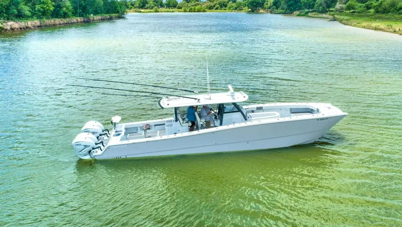 Slide: The Image of 2022 Freeman 47T boat on a calm river with lush green surroundings. - 1