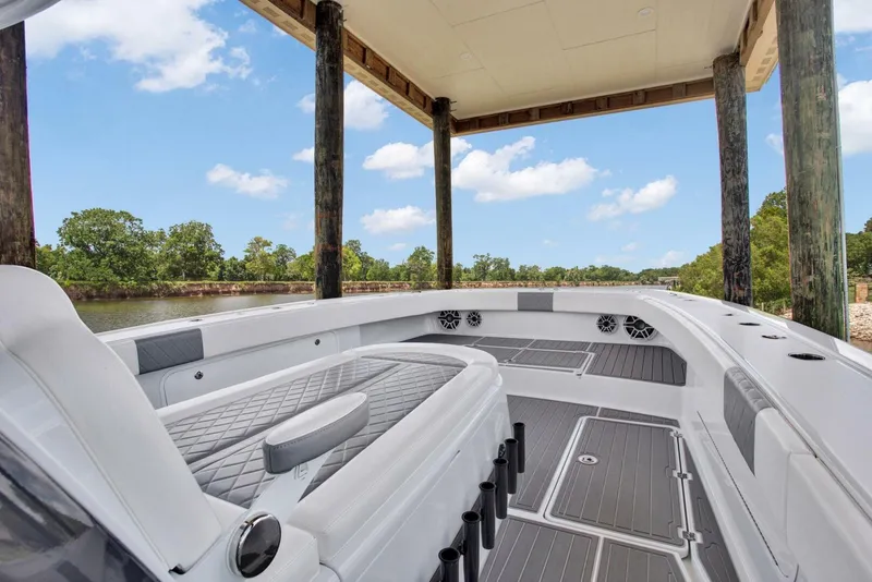 Slide: The Image of 2022 Freeman 47T boat interior with sleek seating and spacious deck under a canopy. - 16