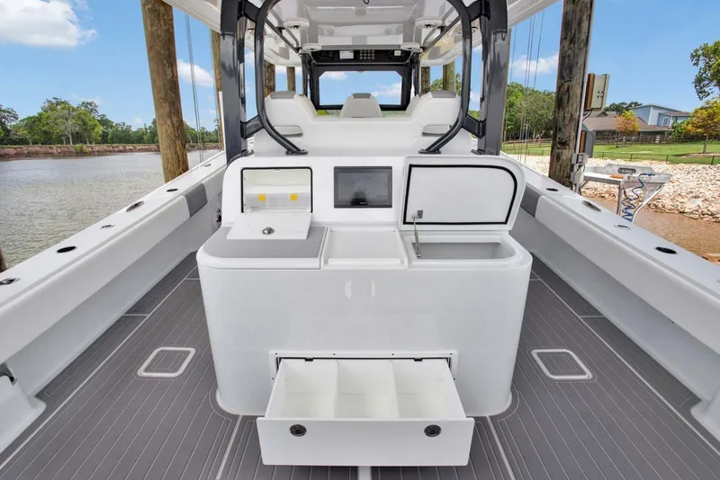 Slide: The Image of 2022 Freeman 47T boat interior with storage compartments and seating, docked by a scenic river. - 19