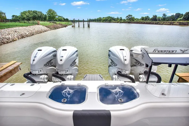 Slide: The Image of Freeman 47T 2022 boat with four engines on a serene river. - 21