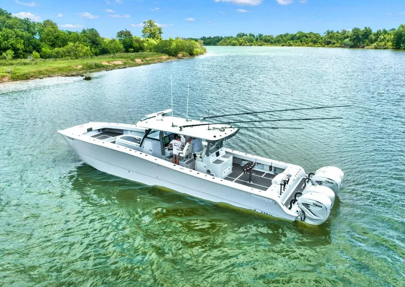 Slide: The Image of 2022 Freeman 47T boat on a serene lake with lush green surroundings. - 5