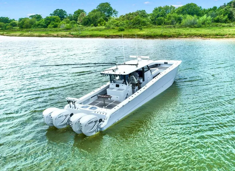 Slide: The Image of 2022 Freeman 47T boat on calm water near a lush, green shoreline. - 6