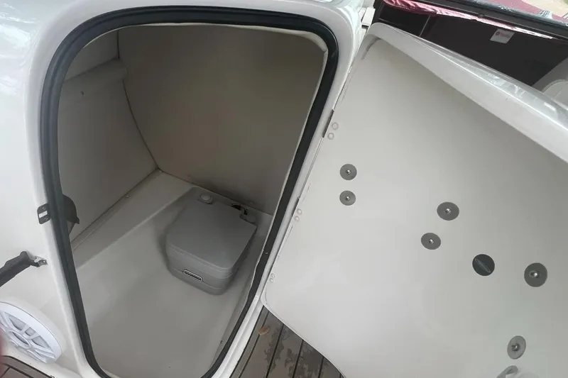 Slide: The Image of 2006 Chaparral Sunesta 254 boat interior storage compartment with portable toilet. - 14