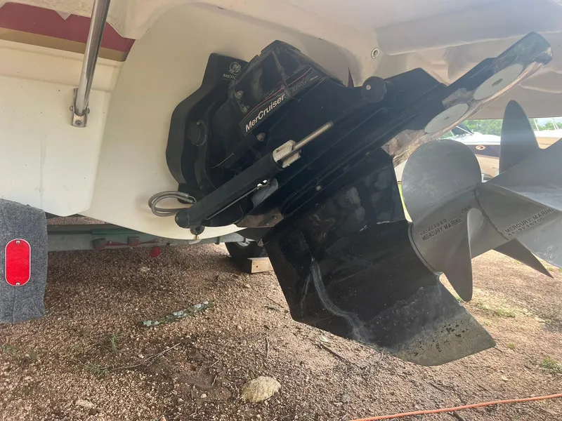 Slide: The Image of 2006 Chaparral Sunesta 254 boat with MerCruiser outdrive and propeller, parked on gravel. - 23