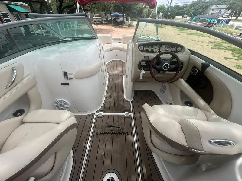 Slide: The Image of 2006 Chaparral Sunesta 254 boat interior with beige seating and wood flooring. - 9