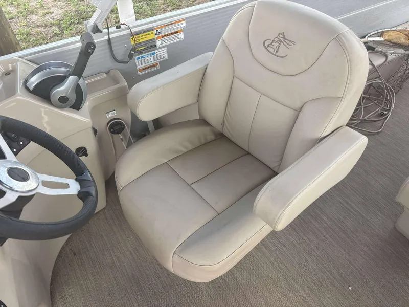 Slide: The Image of Captain's chair on 2019 Misty Harbor 2085 Adventure CF boat, featuring beige upholstery and steering wheel. - 10