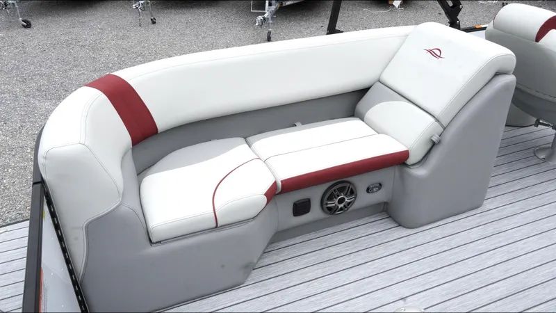 Slide: The Image of 2025 SunCatcher Select 322RC boat seating with white and red upholstery, featuring built-in speaker. - 23