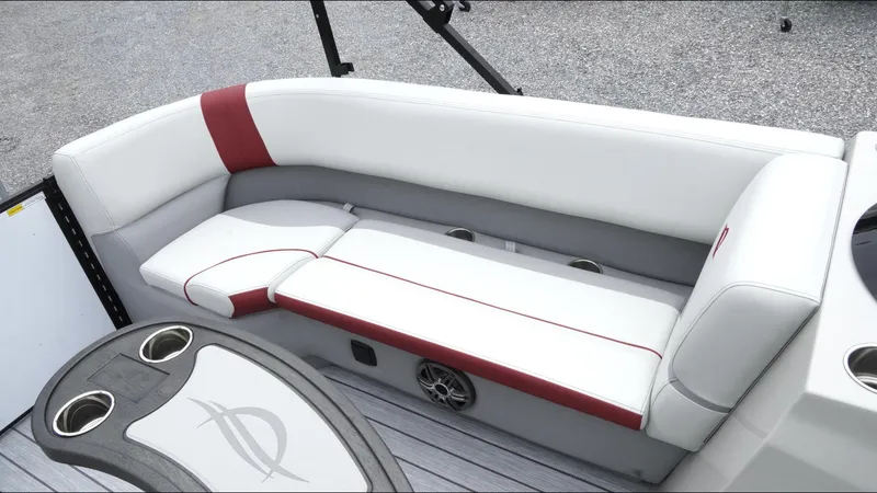 Slide: The Image of 2025 SunCatcher Select 322RC boat interior with white and red seating, cup holders, and speaker. - 25