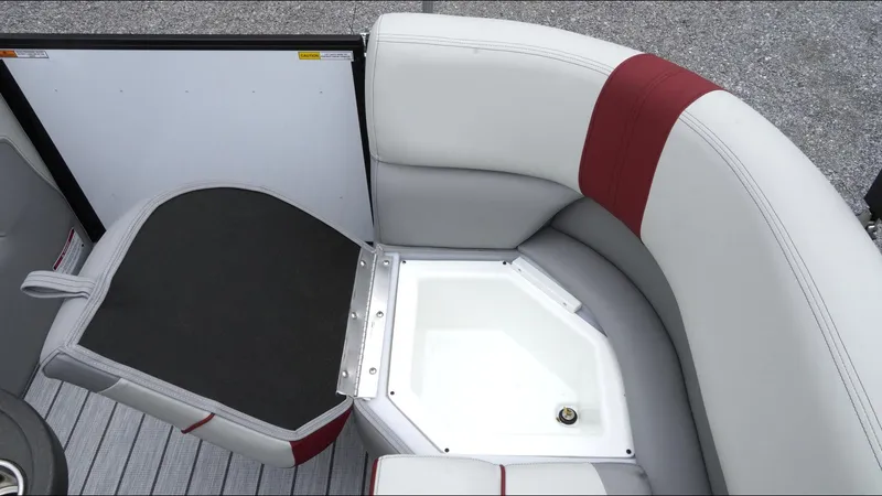 Slide: The Image of 2025 SunCatcher Select 322RC boat seating with storage compartment, featuring gray and red upholstery. - 28