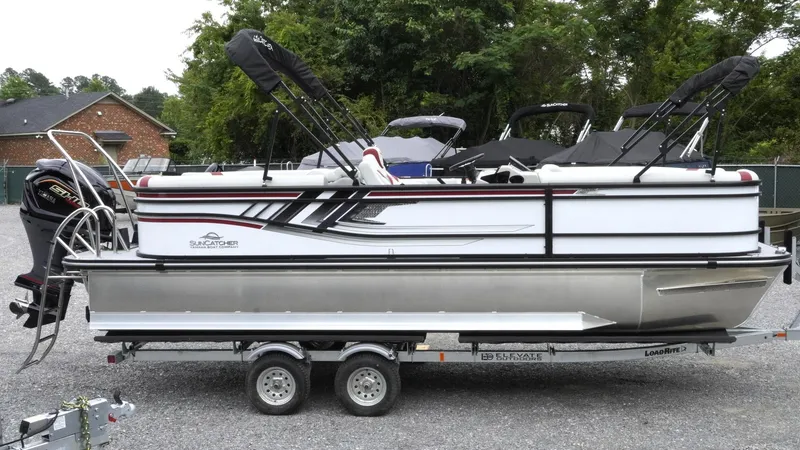 Slide: The Image of 2025 SunCatcher Select 322RC pontoon boat on trailer, parked outdoors. - 3