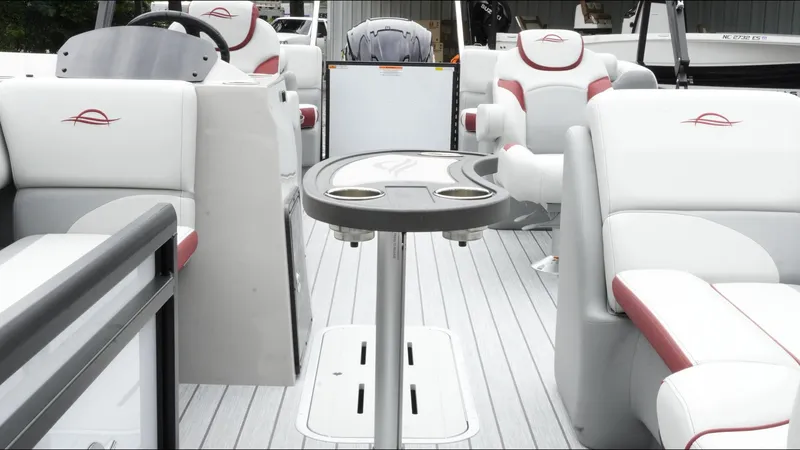 Slide: The Image of 2025 SunCatcher Select 322RC boat interior with white and red seating, table, and modern design. - 33